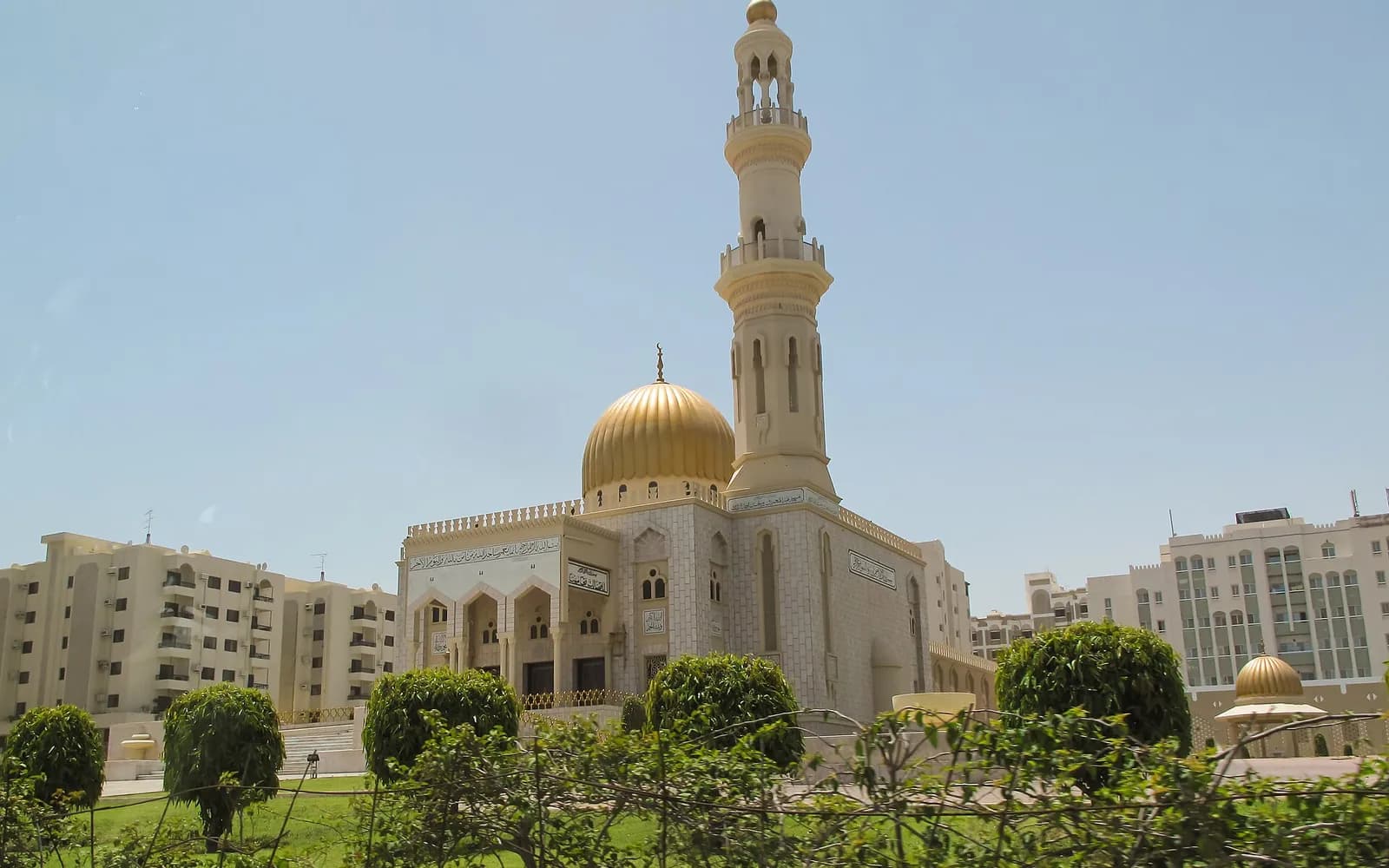 مسجد بقبة ذهبية ومئذنة وسط حيّ سكني في ضواحي مسقط